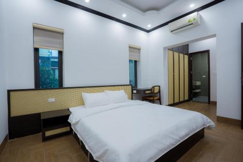 a bedroom with a large white bed and a window at Đậu Homestay Phố Cổ in Ninh Binh