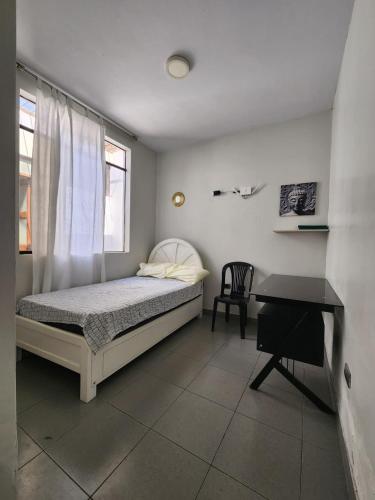 a bedroom with a bed and a desk in it at Casa Arena & Sol in Santa Rosa