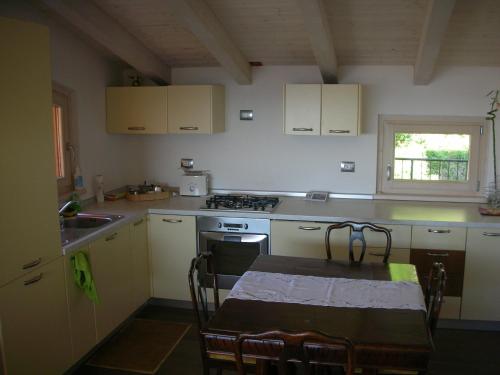 a kitchen with a table and a stove top oven at Villa Susina Casa Vacanze in Toscolano Maderno