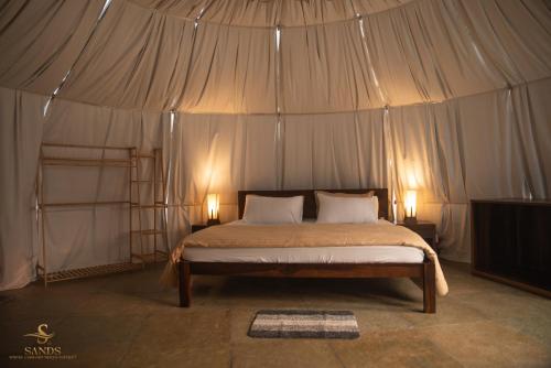 a bedroom with a bed in a tent at Sands - Tajpur in Tajpur
