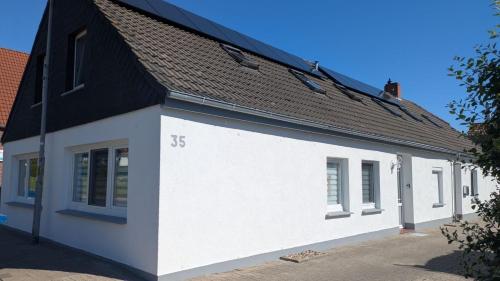 a white building with a black roof at Ankerplatz35 in Wittmund
