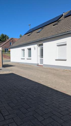 a white house with a brick driveway at Ankerplatz35 in Wittmund