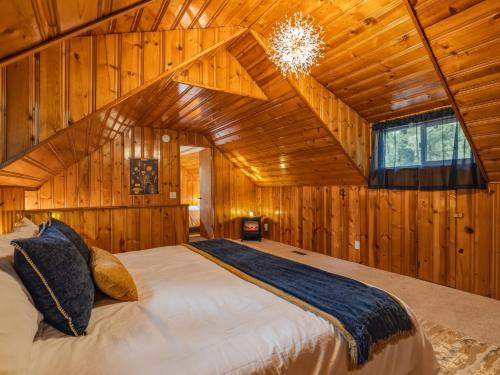 a bedroom with a bed in a wooden cabin at Ravens Retreat in Index