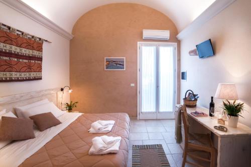 1 dormitorio con cama, escritorio y ventana en Relais Tenuta Campì, en Martano