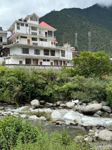 a building on a hill next to a river at KmK Homestay in Rupa