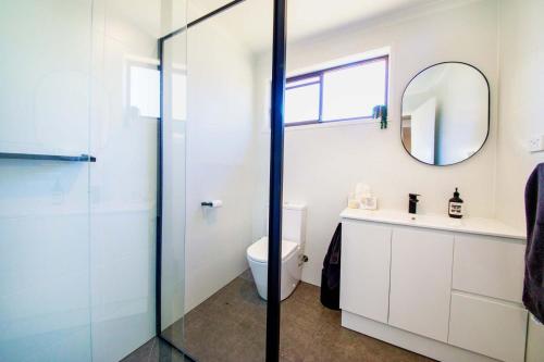 a bathroom with a toilet and a mirror at Bank's Place in Yarrawonga