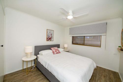 a white bedroom with a bed and a window at Bank's Place in Yarrawonga