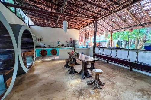 a large room with a table and benches in it at Tubo Tulum Hostel - Unique Stay in Tulum