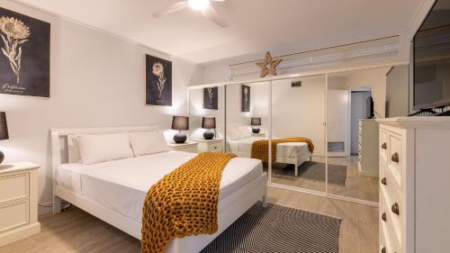 a bedroom with a white bed with a leopard blanket at Waterline Direct Poolside Apartment in Agnes Water