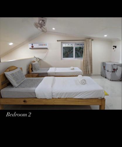 a bedroom with two beds and a window at Sanoraaa Resort in Dabolim