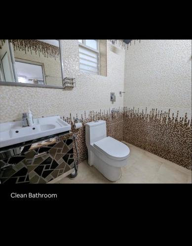 a bathroom with a white toilet and a sink at Sanoraaa Resort in Dabolim