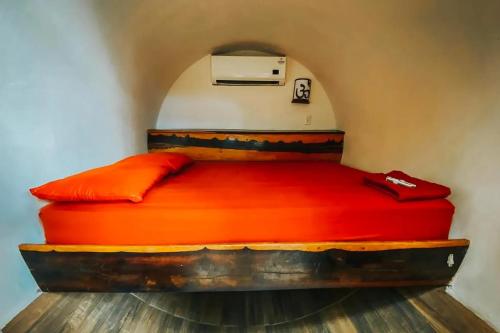 a bed in a room with red sheets at Tubo Tulum Hostel - Unique Stay in Tulum