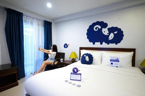 a woman sitting at a desk in a hotel room at Kokotel Khao Lak Seascape in Khao Lak