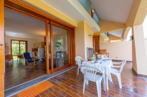 a dining room with a white table and chairs at Sunset in Ranco: Lakeview Townhouse with Private Garden - Happy Rentals in Ranco