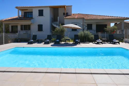 une piscine devant une maison dans l'établissement Les Terrasses Du Grand Large, à Porto Pollo