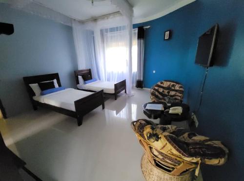 a living room with two beds and a couch at Philo Leisure Gardens in Kalangala