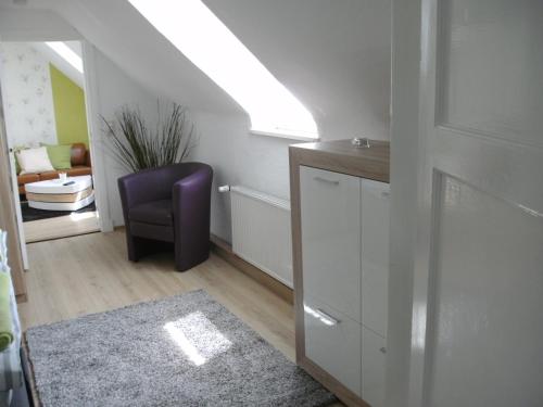 a living room with a purple chair and a window at Ferienhaus am Fuchsberg in Dahme