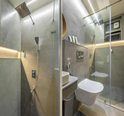 a bathroom with a shower and a toilet and a sink at Hotel Morya Suites IGI Airport in New Delhi