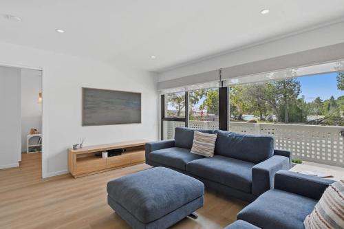 a living room with a couch and a tv at Orford Waterfront Cottage in Orford