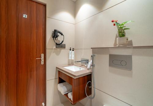 a bathroom with a sink and a wooden door at Playsales SSR in Indore