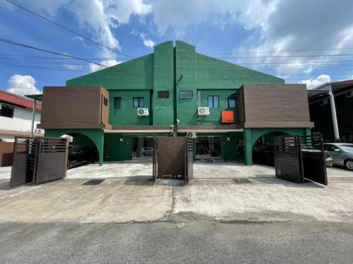 a green building with two gates in front of it at Ipoh TZY's Homestay in Ipoh