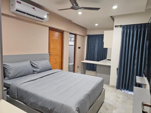 a bedroom with a bed and a ceiling fan at Babus Serviced Apartments in Coimbatore