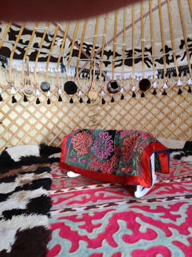 a red bottle sitting on the floor next to a rug at eco house "QUMUSH YURT" in Emgekchil