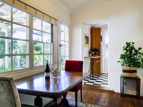 a dining room with a table with wine glasses on it at The old Chiltern bank BnB in Chiltern