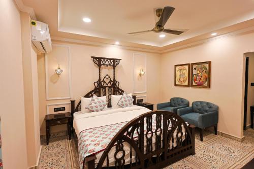 a bedroom with a bed and a blue chair at Ved Mahal in Jaipur