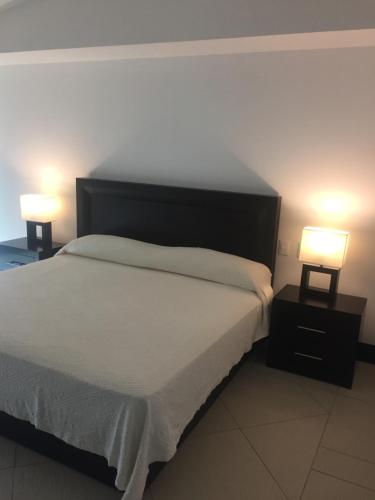 a bedroom with a bed and two lamps on tables at Bay View Grand Marina Condo 1004S in Ixtapa