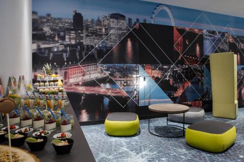 a room with a table and chairs and a view of a city at Novotel Wrocław Centrum in Wrocław