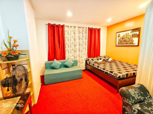 a bedroom with a bed and a couch and a fan at 2B-03 Condo Staycation at Megatower 1 in Baguio