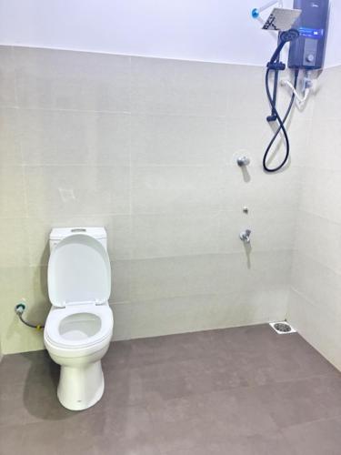 a bathroom with a white toilet in a stall at Amani Rooms in Panadura