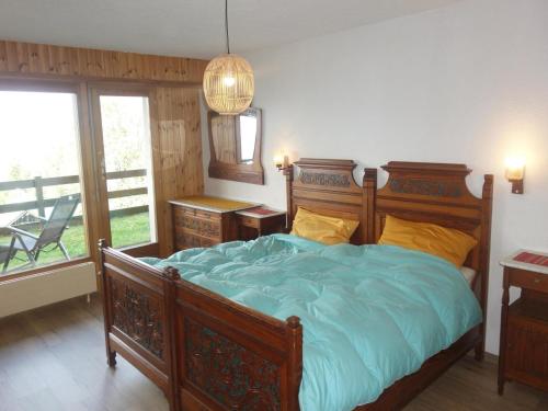 a bedroom with a bed with blue sheets and a mirror at Cozy Apartment With Mountain Views in Veysonnaz