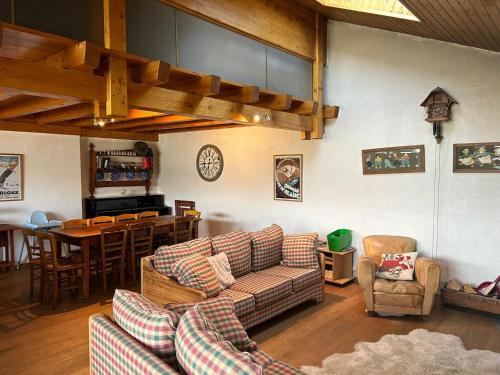 a living room with couches and a kitchen and a table at Pet-friendly chalet in Veysonnaz in Veysonnaz