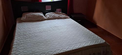 a bed with two pillows on it in a room at CLAUDIA Blessings in Saint Gabriel