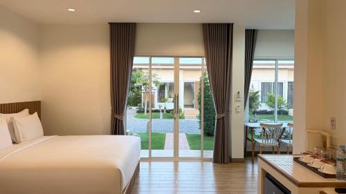 a hotel room with a bed and a sliding glass door at HomeGate Resort in Prachuap Khiri Khan