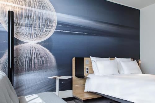 a bedroom with a bed and a large chandelier at Novotel Wrocław Centrum in Wrocław
