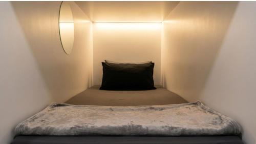 a bed in a small room with a black pillow at Devine Holidays JBR in Dubai