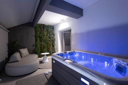 a large bathroom with a blue tub and a chair at Edem in Larisa