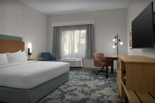 a hotel room with a bed and a desk at Hampton Inn & Suites Phoenix Glendale-Westgate in Glendale