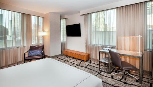 a hotel room with a bed and a desk at The Charter Hotel Seattle, Curio Collection By Hilton in Seattle