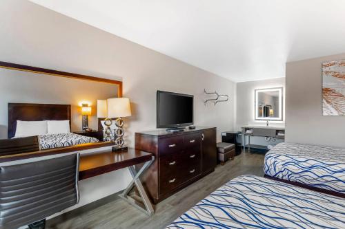 a hotel room with two beds and a television at Rodeway Inn Orange Park - Jacksonville near Naval Air Station in Orange Park