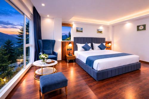 a bedroom with a bed and a table and a window at White Castle Himalayan View by Lavender Hotels in Shimla