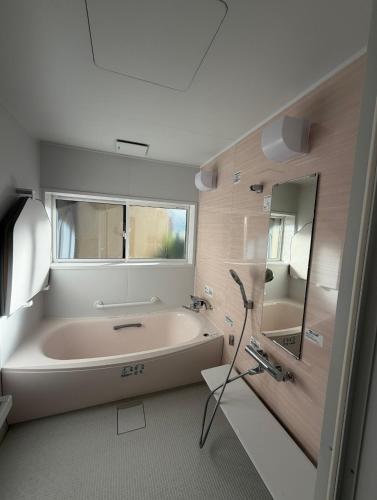a bathroom with a large bath tub and a window at 宿杏 Yado Ann in Kofu