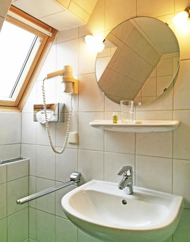 a bathroom with a sink and a mirror at Pension Weserblick in Bremen