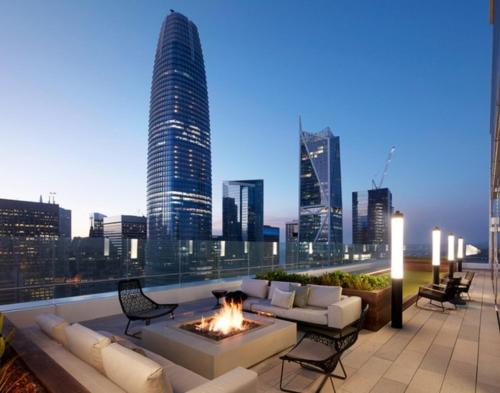 a rooftop patio with a fire pit and a city skyline at Spera in San Francisco