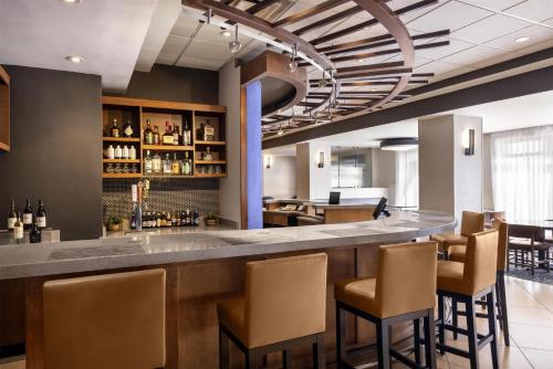 a bar in a restaurant with brown chairs at Hyatt Place El Paso Airport in El Paso