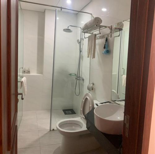a bathroom with a shower and a toilet and a sink at Hotel Kim Thái in Phú Quốc