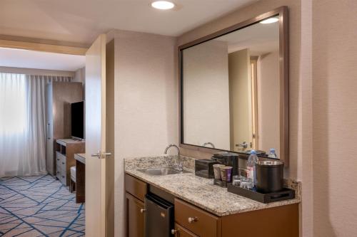 a bathroom with a sink and a large mirror at Embassy Suites by Hilton Seattle Bellevue in Bellevue